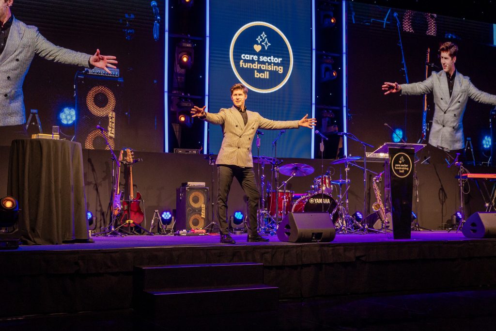 Ben Hanlin awards show host UK engaging guests at a charity gala dinner.
