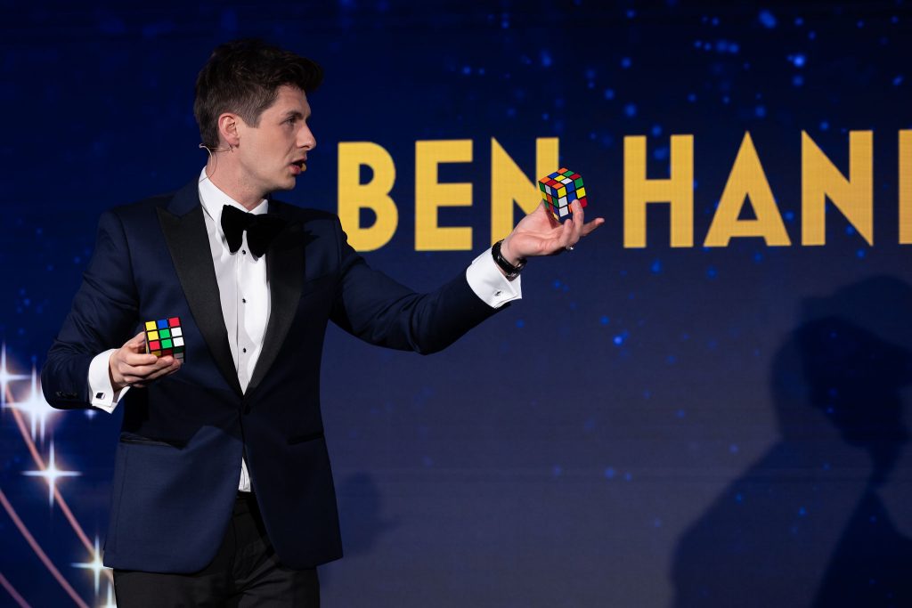 Ben Hanlin performing magic on stage while engaging the audience, demonstrating how to connect with your audience through authenticity and handling failure.